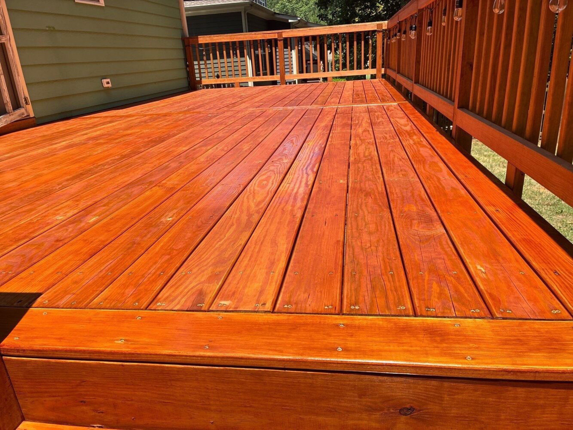Rich, freshly finished decking boards laid true and screwed clean.